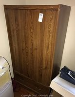 Photo of two matching MDF wardrobes with wood grain finish, closed doors