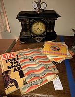 Overview of mantel clock, records and magazines on tabletop