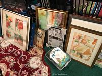 Photo of various frames leaning against a wall on carpet with floral prints, dog portrait, and 'Memories' print