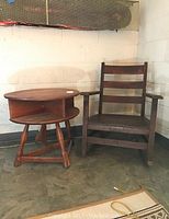 Side view of oak rocker and side table on floor against wall, showing condition and design.