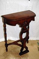 Front view showing demilune tabletop, apron and supports