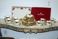 Overall set displayed on console including cups, saucers, plates, platter and box