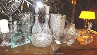 Overview of four crystal decanters, crystal bowls, candy baskets, whale sculpture, and candleholder