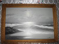 Front view of the full painting and the ornate carved wooden frame showing the moonlit seascape in shades of gray.