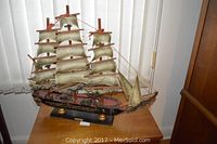 Oblique view of Fragata Espanola model ship on wooden base beside window with vertical blinds.