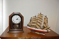 Bulova wooden clock and Great Republic model ship side by side on dresser