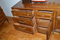 Dresser with some drawers open showing internal storage compartments and brass/bronze hardware.