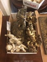 Top view of angel décor including two gold-tone sconces and four angel figurines in different positions inside a cardboard box