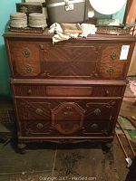Front view showing full chest of drawers with decorative veneer and hardware