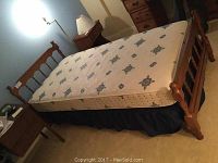 Full view of the extra-long single bed with mattress, headboard, and footboard in a guest room setting.