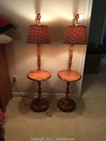 Full view of two wooden side tables with built-in lamps and patterned lampshades standing side by side on carpeted floor against a wall.