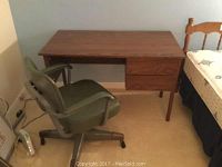 Desk and chair together showing desk's wood grain finish and chair positioning