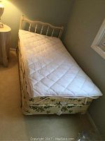 Full twin bed assembled with mattress, box spring, white quilted pad, cream headboard