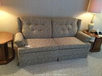 Front view of Kroehler sofa bed showing fabric upholstery, tufted cushions, and pleated skirt base.