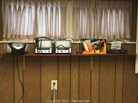 Photo of shelf showing Electrohome portable CD player and radio, two older alarm clock radios, newer clock radio, and boxed Durabeam battery-operated flood light.