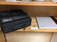 Dell laptop bag and paper cutter on shelf