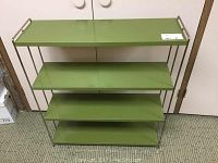 Front view of a four-tier green metal shelf unit showing even spacing and open wire frame sides and back