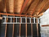 Two photos showing an 8-foot aluminum extension ladder mounted on a wall, fully extended and retracted.