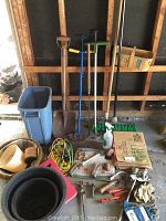 Full view of gardening tools including shovel, weed pullers, edger, broom, cords, pots, gloves, spray bottle, and other accessories