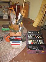 Full view of wooden bucket, tool caddy with hand tools, plastic toolbox, orange cable, and plastic storage boxes