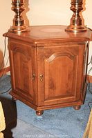 Full view of the Ethan Allen octagonal end table showing wood tone, brass hardware, and panel design.