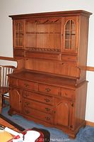 Front view of the full assembled maple breakfront showing upper and lower sections in wood finish with decorative details.