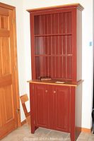 Front view of red wooden Amish cabinet with two open shelves and two closed cabinet doors underneath.