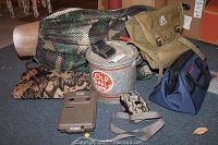 View of all items including two cameras, seat cushion, bucket, bags, and decoy.