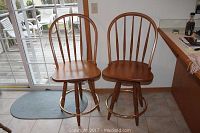 Two wooden bar stools side by side showing their overall condition and design