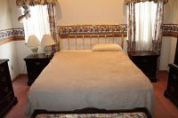 Assembled queen bed showing brass headboard, bedding and full frame.