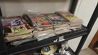 Three stacks of Spider-Man comic books on plastic shelving