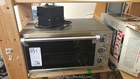 DeLonghi toaster oven front view with power cord on top