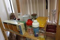 Overview of kitchenware lot showing oak letter rack in box, 4 plastic tankards, a kitchen storage jar, other containers, carafe and decanter