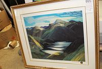 Framed landscape print by Franklin Carmichael showing mountain and lake scene, gold frame and white mat