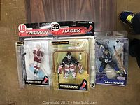 Three McFarlane Toys NHL hockey player figurines new in package: Steve Yzerman, Dominik Hasek, and MacInnis.