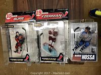 Three McFarlane Toys NHL hockey player figurines in original packaging showing player names Pavel Bure, Steve Yzerman, and Marian Hossa.