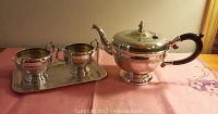 Full set showing silverplate teapot, cream, sugar, and tray on pink cloth
