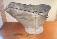 Side angled view of galvanized coal scuttle showing spout and handle construction