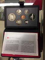 Photo of the opened black display case showing the six coins included in the 1985 Canadian Silver Double Dollar National Parks set along with the informational booklet inside the case.