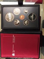 Photo showing the 1984 Canadian silver double dollar coin set commemorating Toronto 200 year anniversary with various smaller denomination coins arranged in a black display case within a red Royal Canadian Mint protective box.