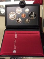 Photo of the 1983 silver Canadian Double Dollar Set in a black fold-open case with a red interior lining displaying seven coins.