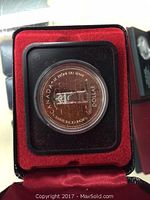 Close-up photo of the 1977 Canadian silver dollar coin in a red velvet-lined black presentation case, showing the Peace Tower design and inscriptions on the coin.