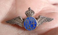 Close-up front view of the sterling silver RCAF pin showing blue enamel 'RCAF' letters, crown and wings.