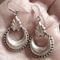 Front view of the vintage sterling silver hoop earrings showing detailed outer beaded edge and leaf motif at top.