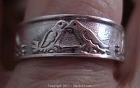 Close-up image of the sterling silver ring band showing two facing love bird engravings.