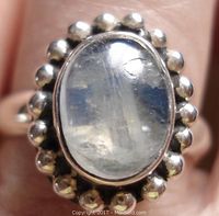 Close-up front view of the ring showing oval moonstone cabochon set in sterling silver with bead frame.