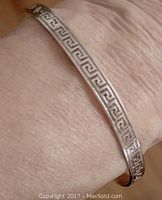 Bracelet shown on wrist highlighting Greek key pattern design around circumference.