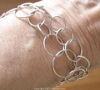 Close-up photo of the silver circle link bracelet on wrist, showing the size and design of circular links.