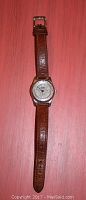 Full view of Kodiak quartz wristwatch with brown leather band laid flat