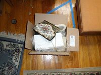 Box containing 10 vintage clutch purses, one visible with floral embroidery and gold chain